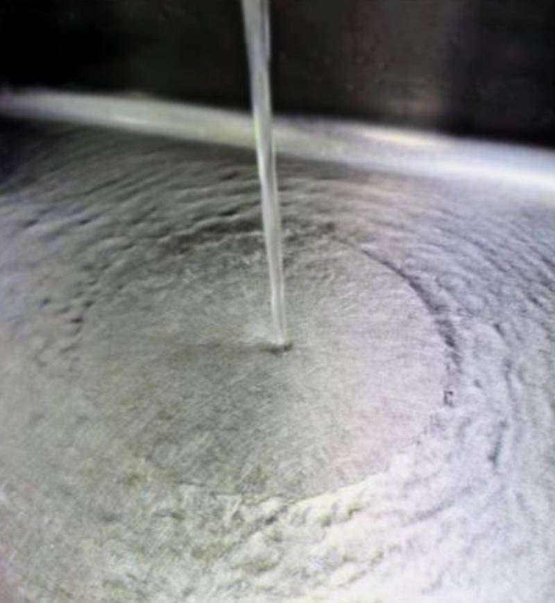 Hydraulic jump in a kitchen sink. In this image, the clearly defined hydraulic jump can be seen in the difference between the smooth inner circle of shallow and fast water, and the ripples of deeper, slower water beyond. 