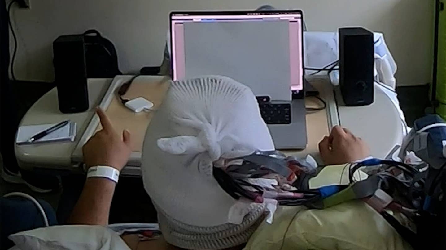 A hearing system monitoring this man's brain activity amplifies a conversation played on his left while quieting one on his right, based on which conversation his brainwaves suggest he is paying attention to.