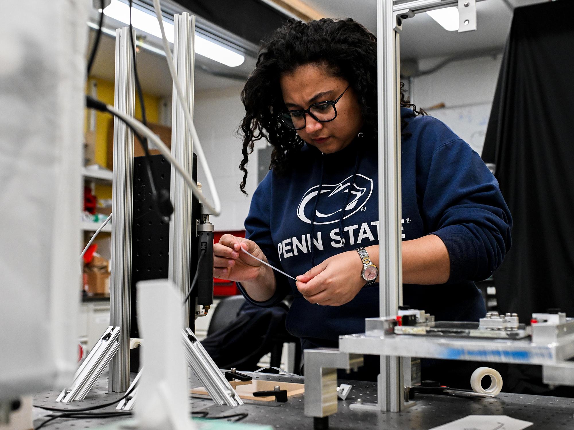 Postdoctoral scholar Sebanti Chattopadhyay prepares to load adhesive tape into the device.