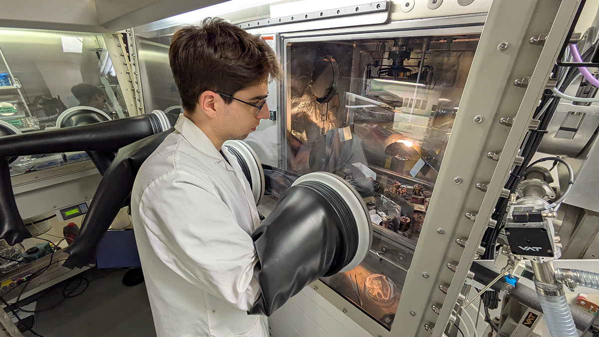 Arnaud Petit, a PhD student and co‑author of the study, prepares a sample on which a thin organic film will be deposited using vacuum thermal evaporation.