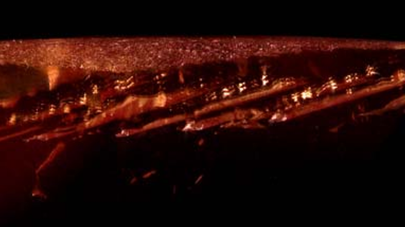 A series of en echelon hollow tube inclusions near the girdle of the kyawthuite gem. These can also be seen along the top of the gem