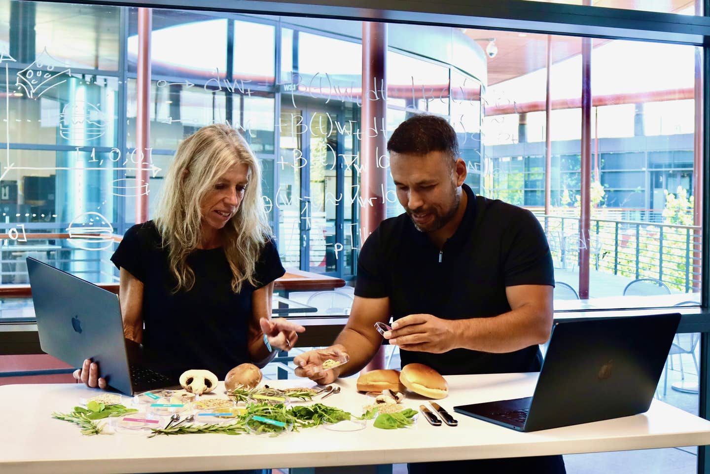 Ellen Kuhl and Vahidullah Tac inspect ingredients for the AI-designed sustainable mushroom burger and discuss the computational model behind BurgerAI.
