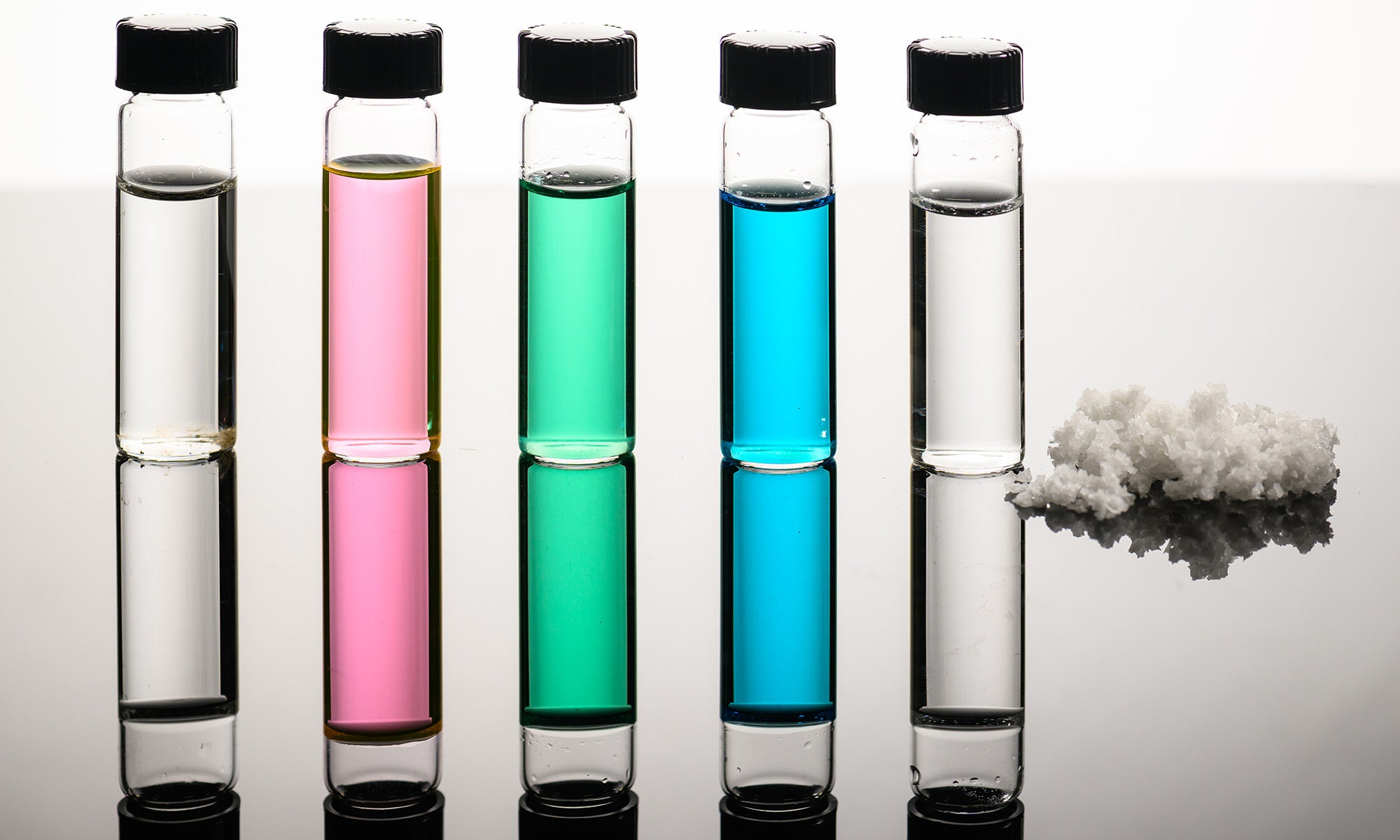 Vials of seawater, Great Salt Lake water, nickel sulfate, copper chloride wastewater, and desalinated water, along with recovered salts show how a new approach developed by URochester researchers turns natural and industrial waters into fresh water and reusable minerals.