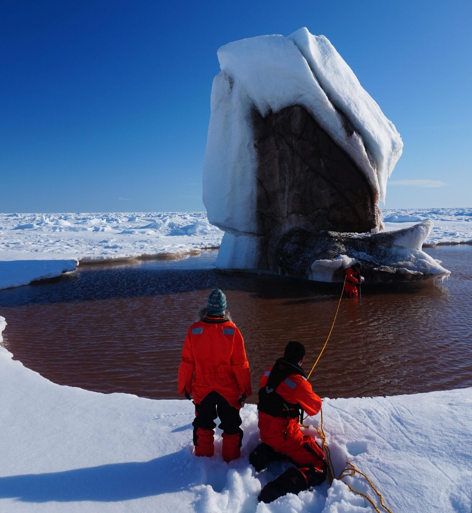 Iceberg embedded in sea ice with surface stones, potentially reflecting supraglacial debris or exposure of debris-rich basal ice, near HAUSGARTEN.