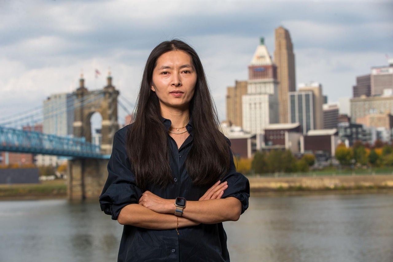University of Cincinnati Professor Dongmei Feng, pictured on the banks of the Ohio River, is studying ways to protect drinking water derived from rivers from periodic harmful algal blooms.