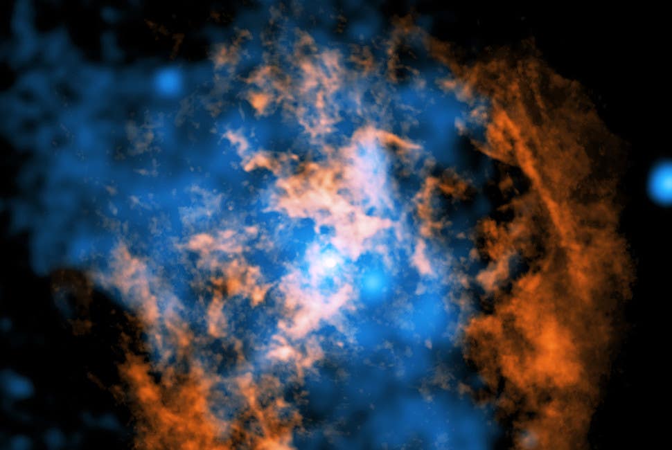 This composite image shows evidence for a wind blowing away from Sagittarius A* (Sgr A*), the supermassive black hole in the center of our galaxy. The white dot in the center of the image shows Sgr A*. In orange is data from the Atacama Large Millimeter/Submillimeter Array radio telescopes in Chile, mapping the location of cold gas composed of carbon monoxide in the image. In blue is X-ray data from NASA’s Chandra X-ray Observatory.