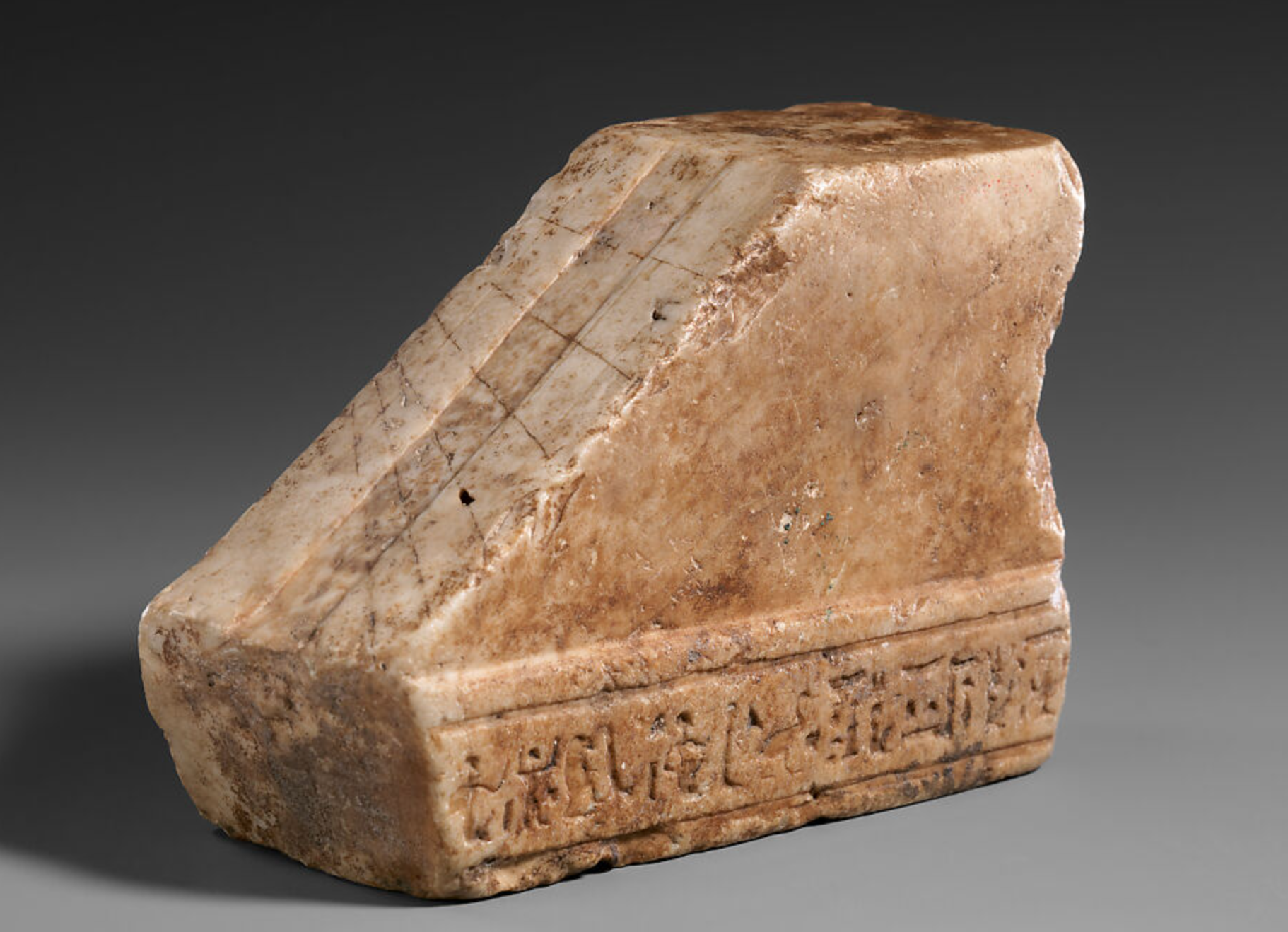 One of a handful of portable timepieces known from ancient Egypt, this fragment is from the type that told time by measuring the length of the sun's shadow. Preserved here is the block with a sloping face with a series of parallel and oblique lines engraved on its face to mark off the time. The original piece would also have had a perpendicular block set up in front of the sloping face to serve as a gnomon and cast a shadow.