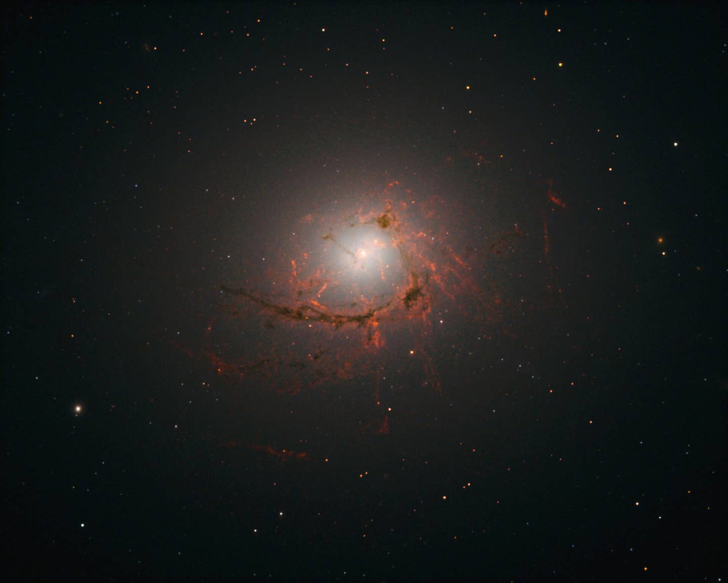 An image of elliptical galaxy NGC4696 located at the center of the Centaurus Cluster taken by the Hubble Space Telescope. This image shows dusty filaments surrounding the center of the galaxy.