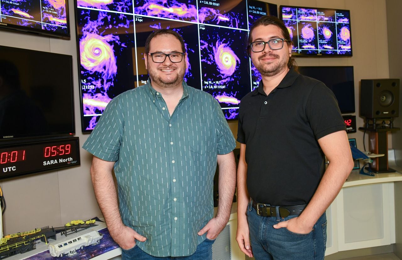 Dr. Asa Bluck, Assistant Professor of Physics, stands with Camilo Casimiro, an FIU Physics graduate student.