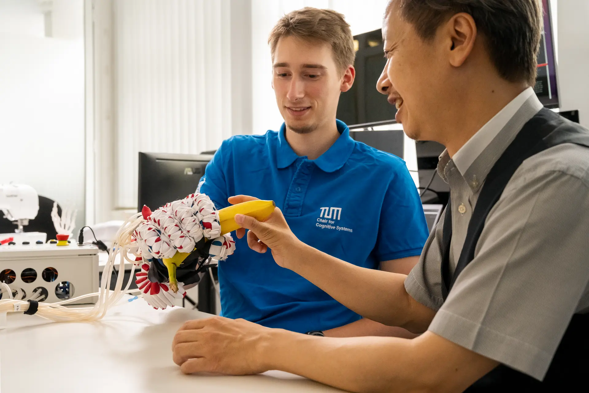 Researcher Nicolas Berberich (left) and Prof. Gordon Cheng are testing the new soft-hand exoskeleton.