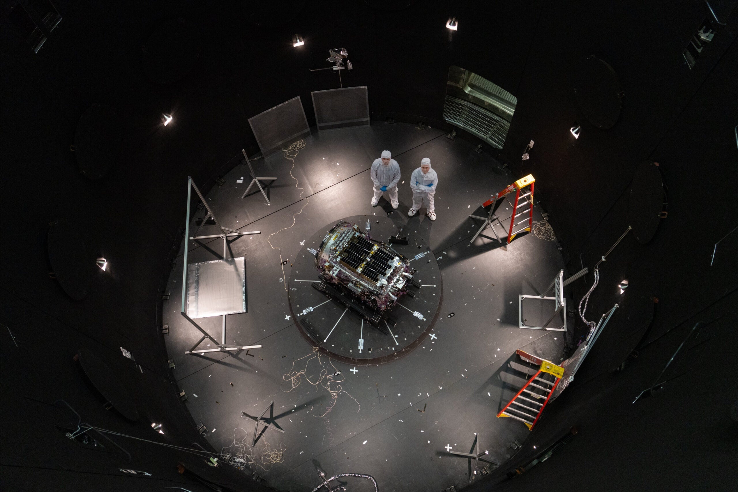 This photo provided by NASA shows Kieran Wilson, LINK’s principal investigator, and Hunter Robertson, a space systems engineer, both at Katalyst Space, standing next to their spacecraft inside the SES (Space Environment Simulator) at NASA’s Goddard Space Flight Center in Greenbelt, Md., April 17, 2026, ahead of thermal vacuum testing. 