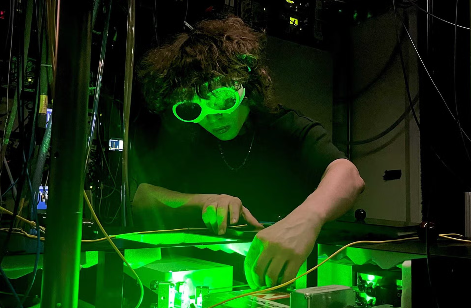 Luca Huber, a doctoral researcher at ETH Zurich, fine-tunes a laser used to study calcium isotopes.