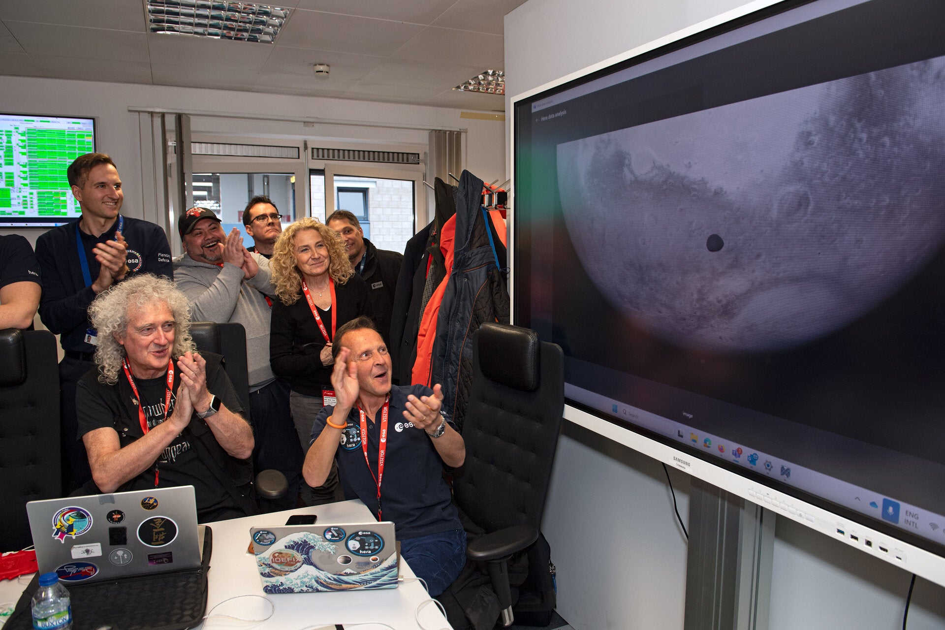 ESA's Hera science team, including astrophysicist, stereoscopist and guitarist Sir Brian May, foreground left, and Principal Investigator Patrick Michel, right, celebrate as images from the mission's gravity-assist Mars flyby on 12 March 2025