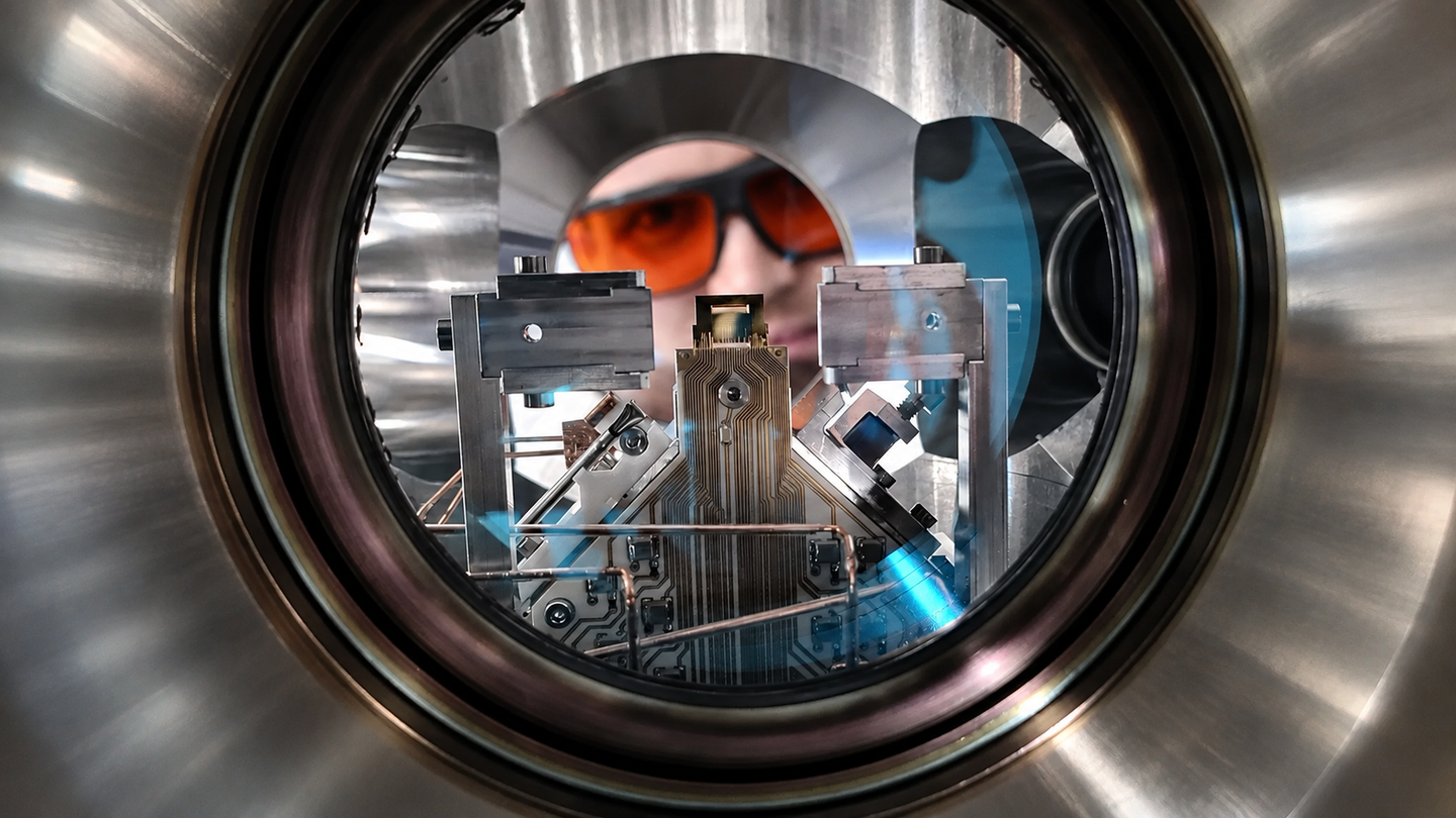 First author Philip Leindecker looks into the ultrahigh-vacuum chamber of a quantum computer at PSI that operates with trapped ions.