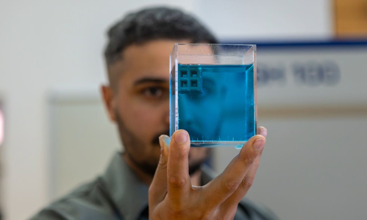 Dr Jordan Noronha holding a sample of the floating titanium.