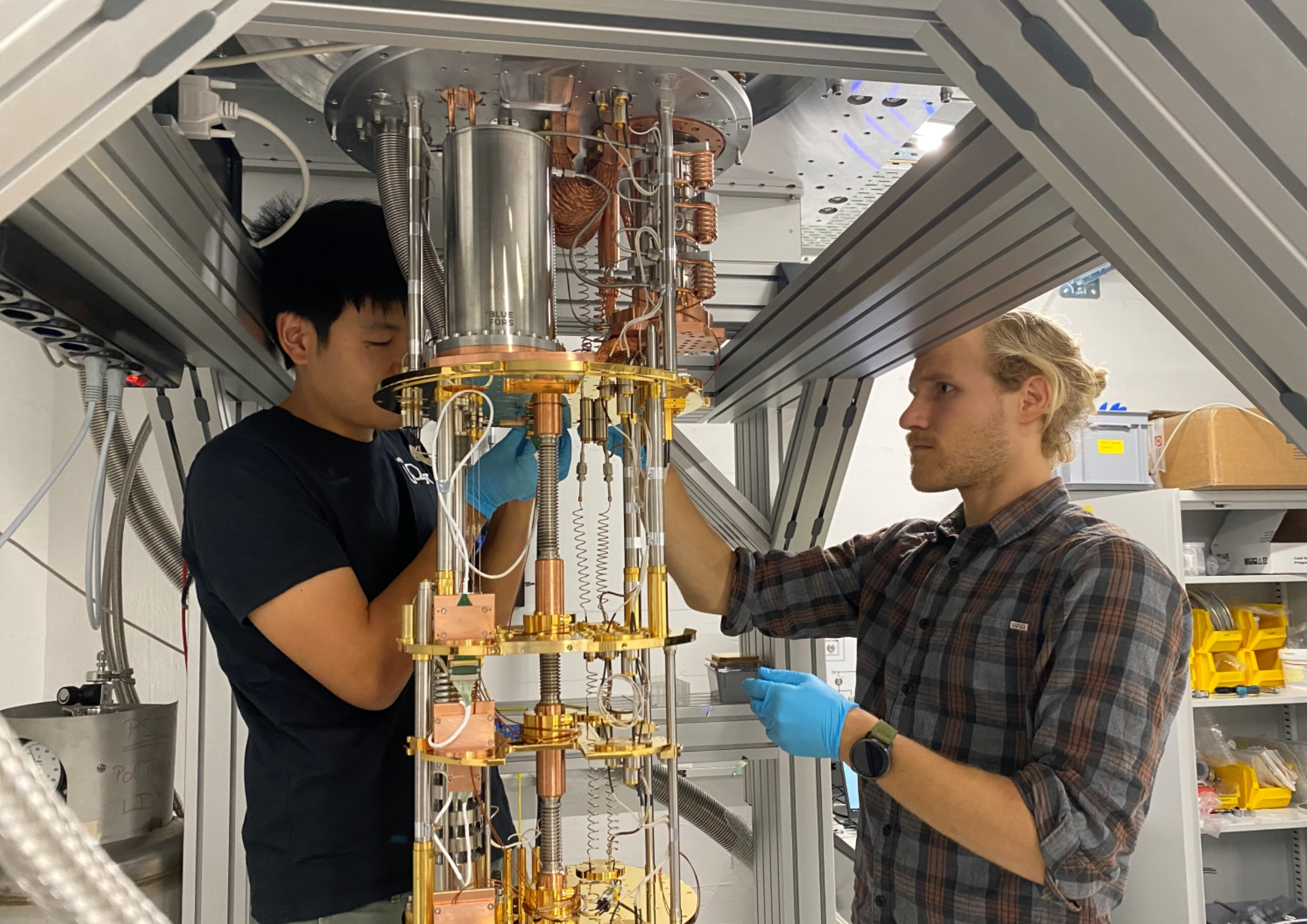 Jesse Zhang (left) and Paul Wegmann complete detector wiring in the dilution refrigerator.
