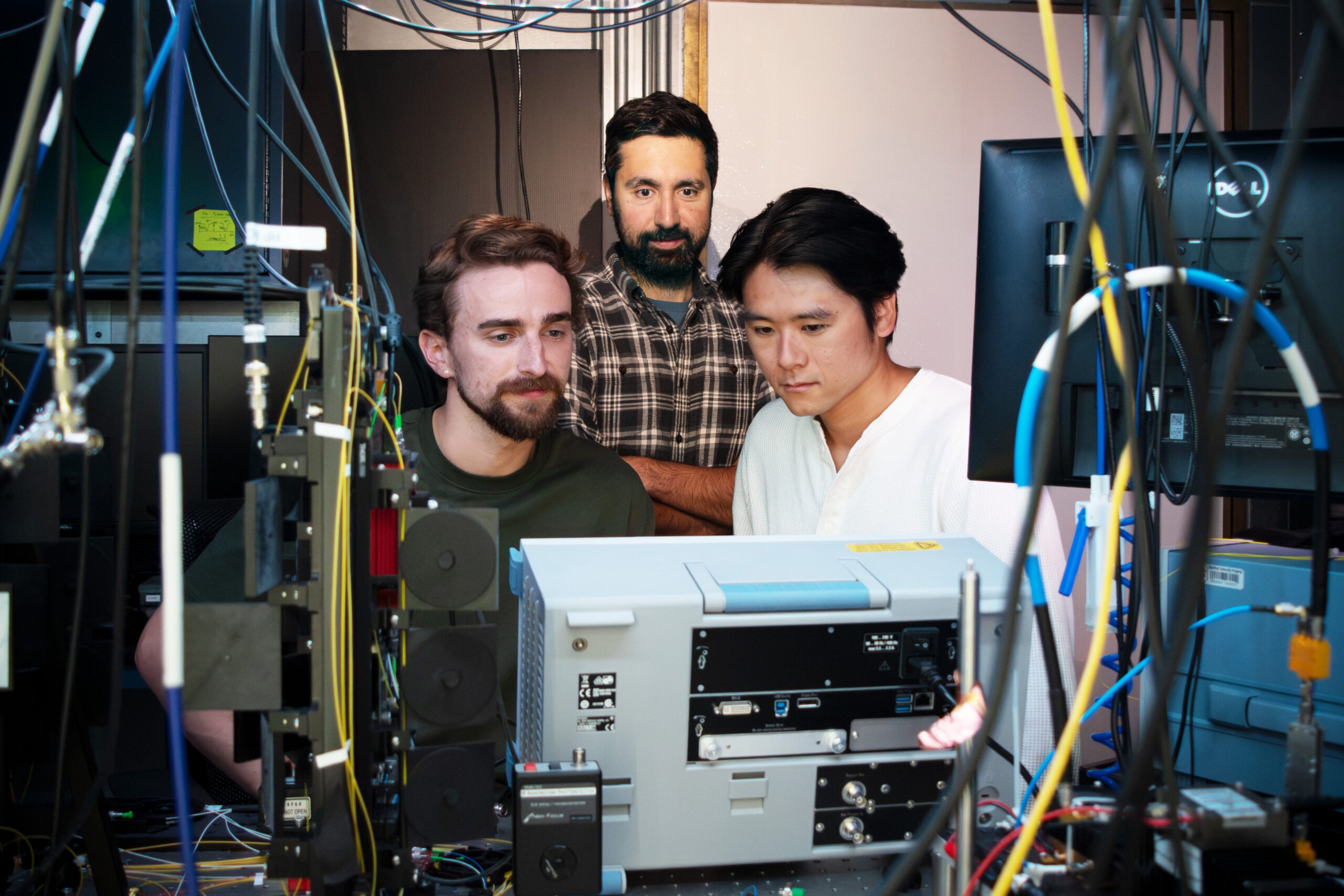 Study co-authors Erik Szakiel (left), Professor Amir Safavi-Naeini, and Takuma Makihara look at radio frequency instrumentation.
