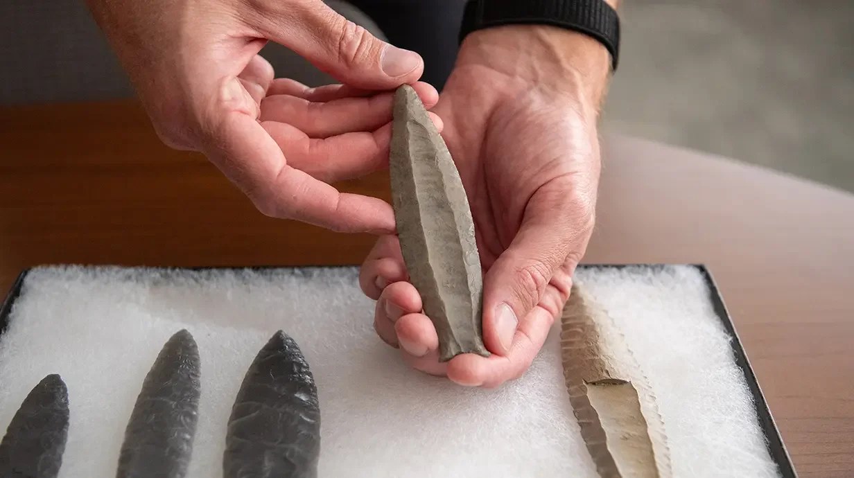 Jesse Tune, director of the Center for Archaeological Research, examines a replica of a Cumberland spear point, one of two types of stone projectiles