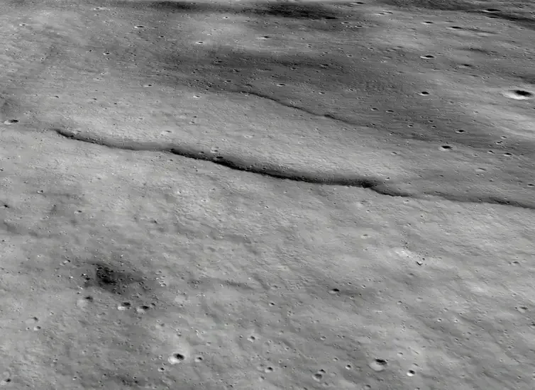 Perspective view of lobate scarps on the floor of the moon’s Mouchez L impact crater. This view shows the cliff-like scarp face of the larger scarp in the foreground and a smaller scarp in its back-scarp area. Elevation data indicates the larger scarp has a maximum relief (height above the surrounding terrain) of over 100 meters (over 300 feet).