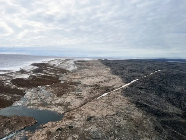 The end of a glaciation. Prominent trimline marks the 1960 extent of the Barnes Ice Cap. The dark colored landscape hosts mature vegetation and lichen cover, whereas the light-colored rock is vegetation free. Ice margin retreat from this trimline has reversed ~2,000 years of ice margin expansion.