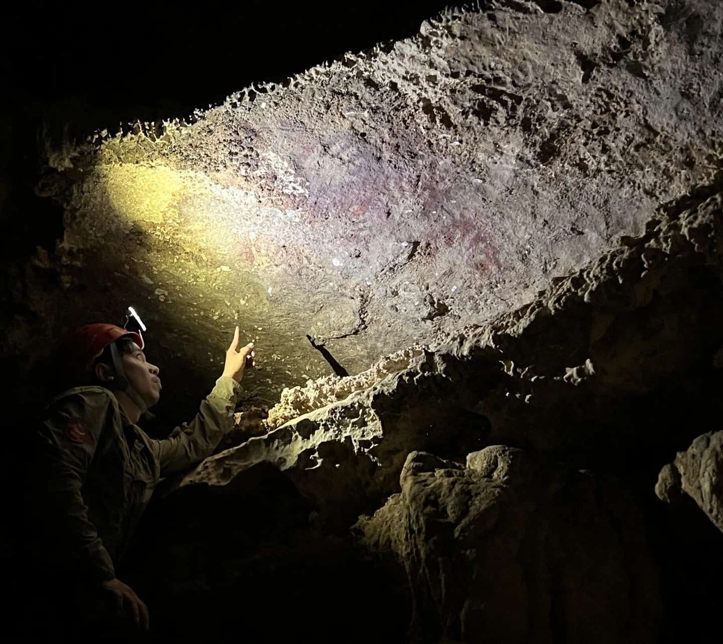 A fragmentary hand stencil preserved in a limestone cave on Indonesia’s Muna Island was found alongside much more recent rock art.