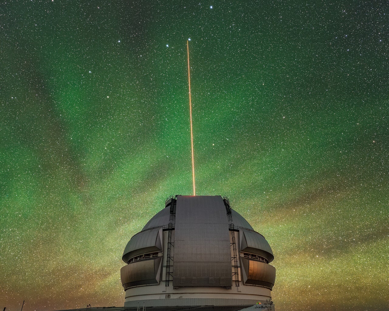 Gemini North’s laser shines through airglow. The Gemini North telescope’s laser guide star beams up into the atmosphere. 